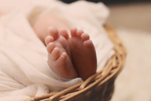 Baby's Feet on Brown Wicker Basket - Wise Options For a Good and Happy Life By Tomer Levi 