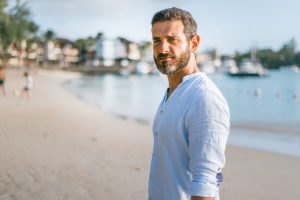 man standing on beach during daytime - Opiniones LeoTradez